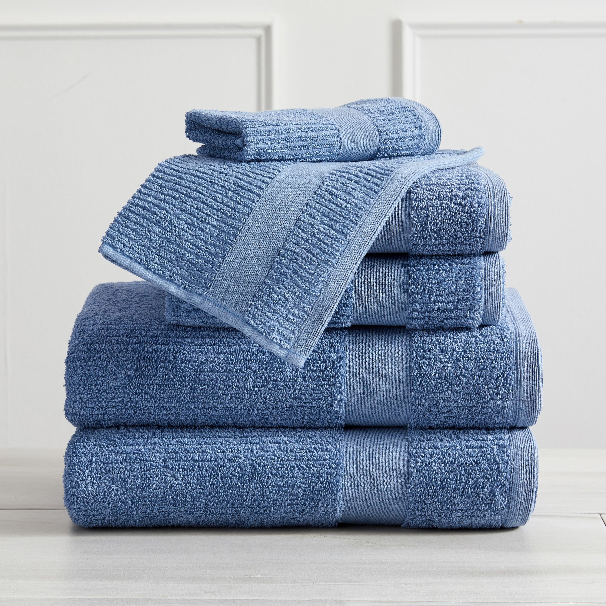 Roda Collection Cotton Ribbed Bath Towels by Market & Place featuring premium 100% cotton construction with a textured ribbed weave. Available in multiple colors and set configurations, including bath towels, hand towels, and washcloths, shown folded, stacked, and styled to highlight their soft, plush, and highly absorbent design.