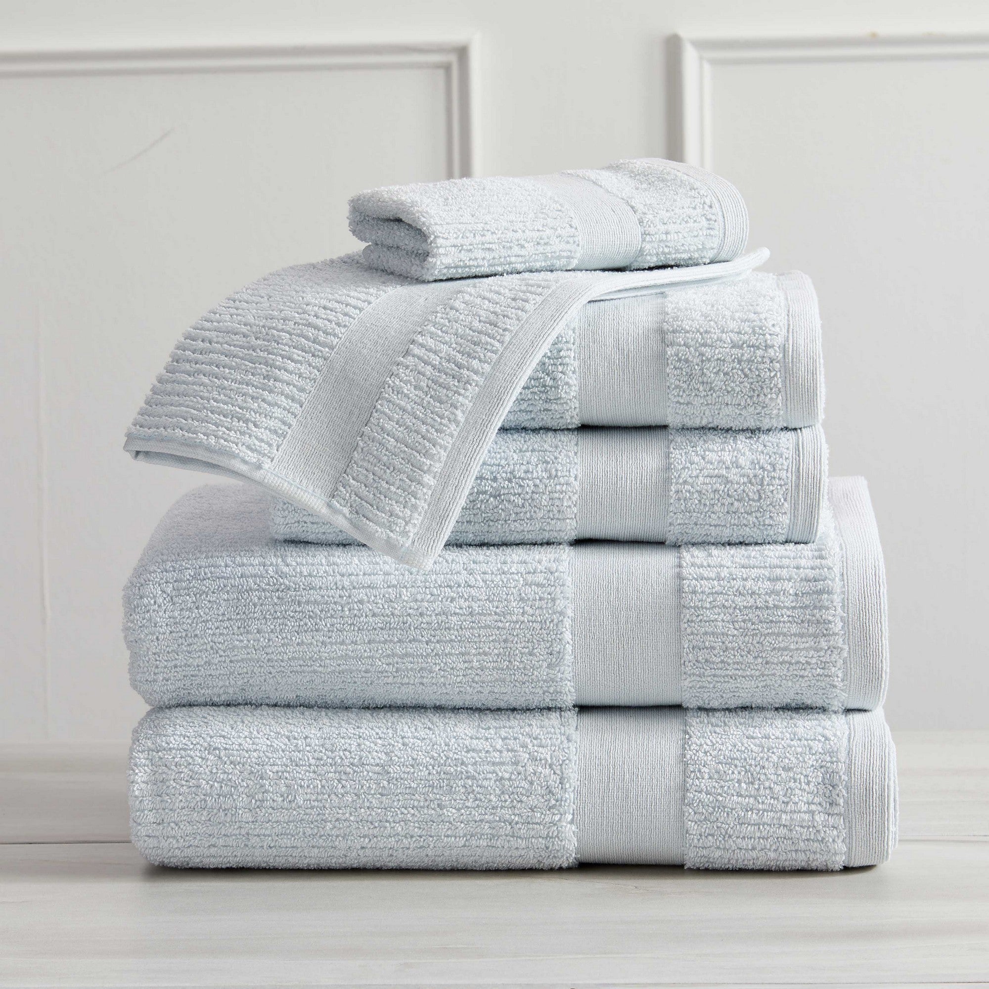 Roda Collection Cotton Ribbed Bath Towels by Market & Place featuring premium 100% cotton construction with a textured ribbed weave. Available in multiple colors and set configurations, including bath towels, hand towels, and washcloths, shown folded, stacked, and styled to highlight their soft, plush, and highly absorbent design.