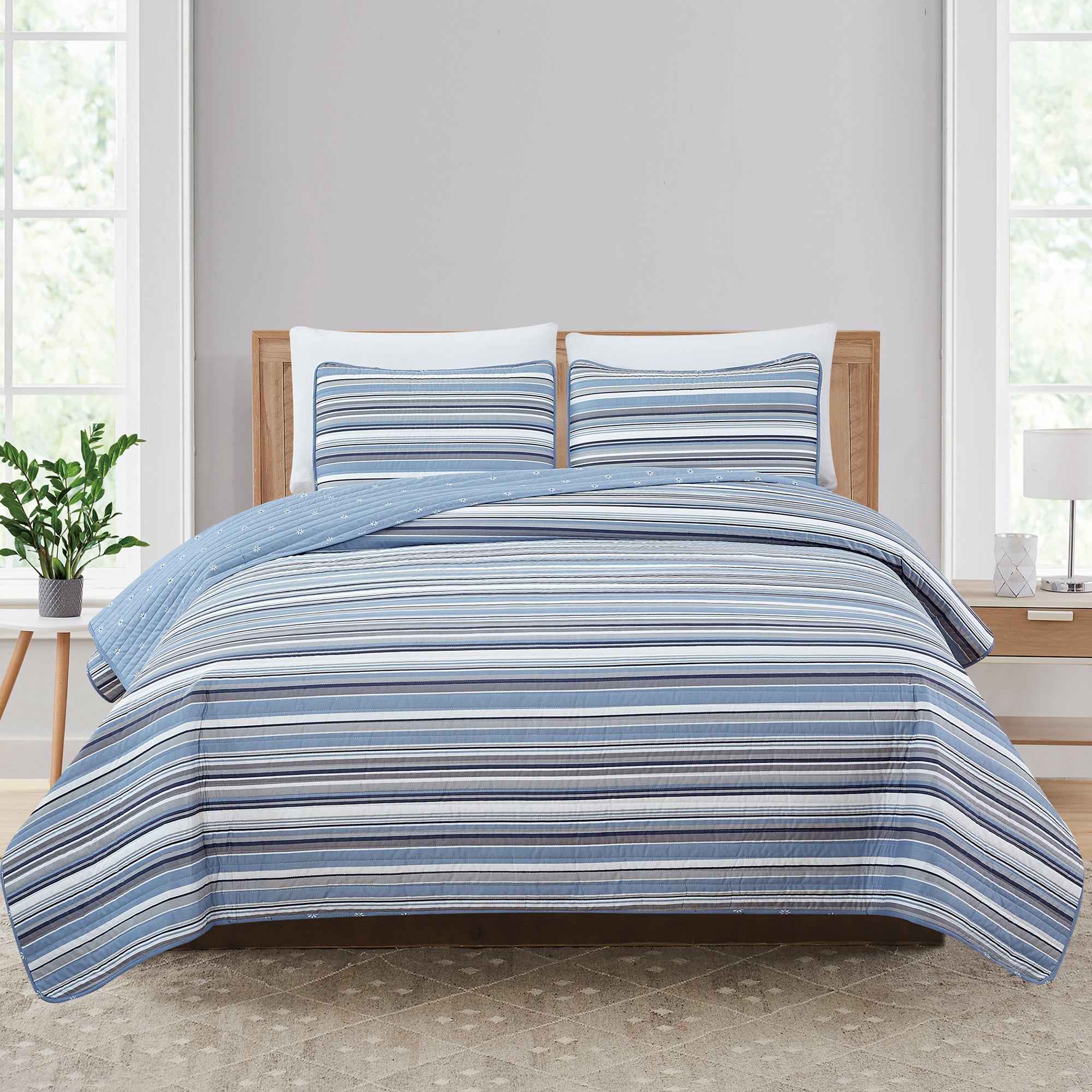 Elise Collection striped quilt set featuring classic blue and gray stripe patterns with a coordinating floral reverse, shown in multiple styling views and close-up detail shots. Soft, reversible bedding with matching shams, designed for year-round comfort and casual bedroom décor.