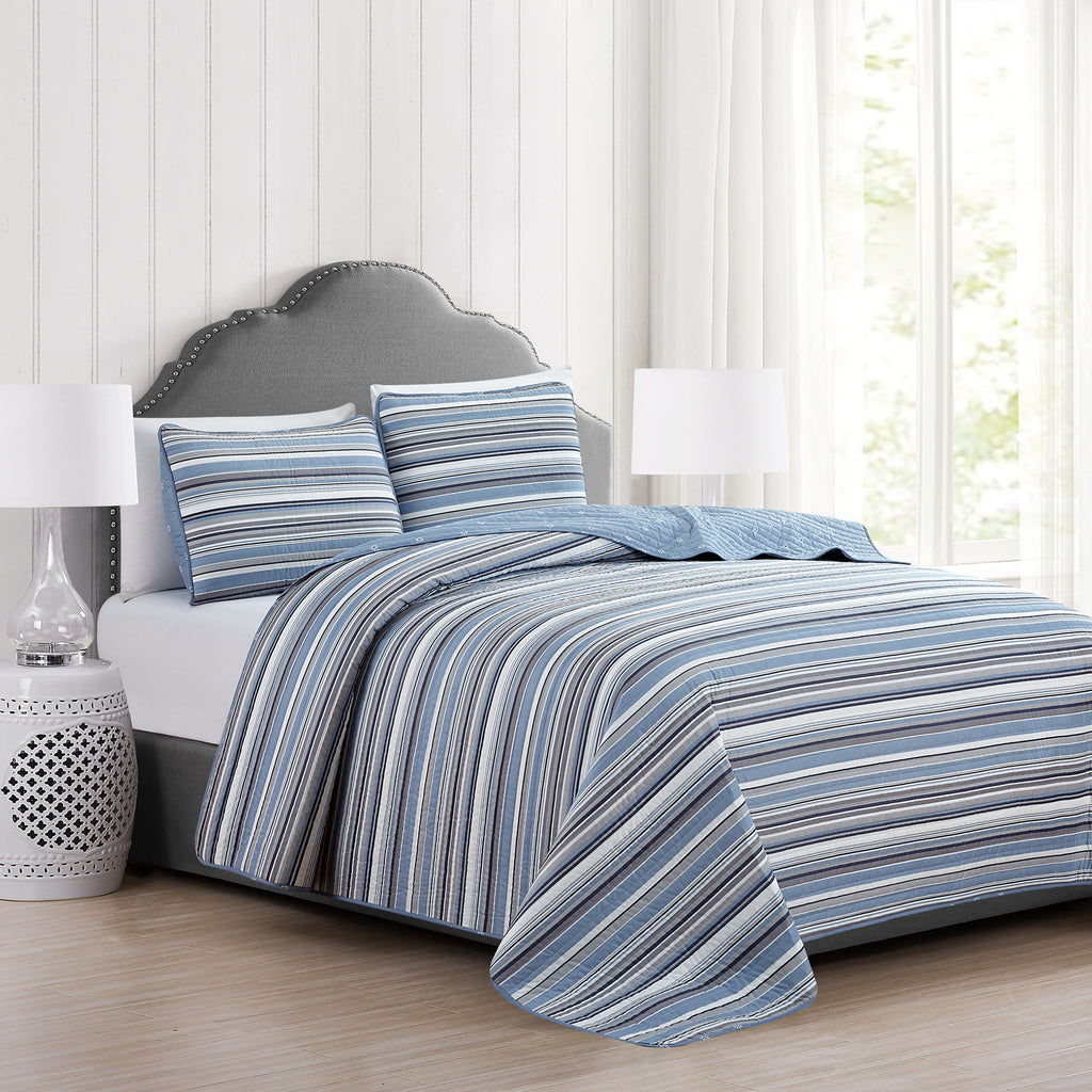 Elise Collection striped quilt set featuring classic blue and gray stripe patterns with a coordinating floral reverse, shown in multiple styling views and close-up detail shots. Soft, reversible bedding with matching shams, designed for year-round comfort and casual bedroom décor.