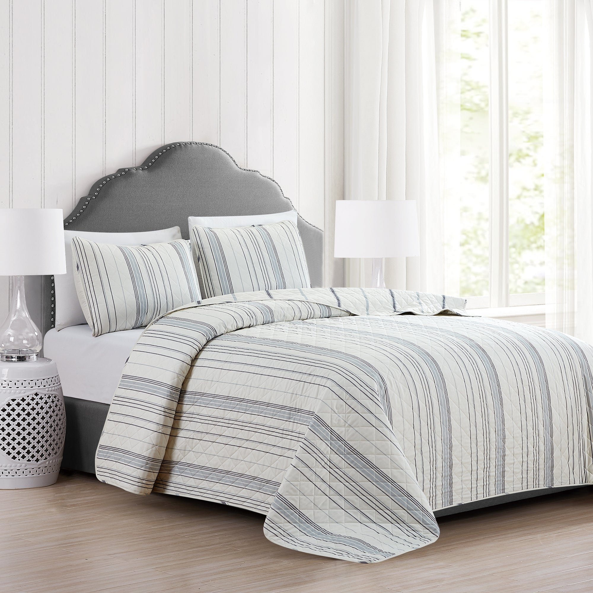 Sofia Collection striped quilt set featuring classic blue and white stripes with a reversible design, shown on beds and in close-up detail views. Soft, lightweight bedding with coordinating shams, styled in a bright and casual bedroom setting.