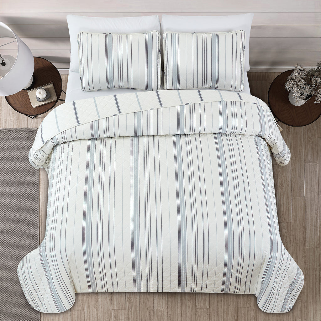 Sofia Collection striped quilt set featuring classic blue and white stripes with a reversible design, shown on beds and in close-up detail views. Soft, lightweight bedding with coordinating shams, styled in a bright and casual bedroom setting.