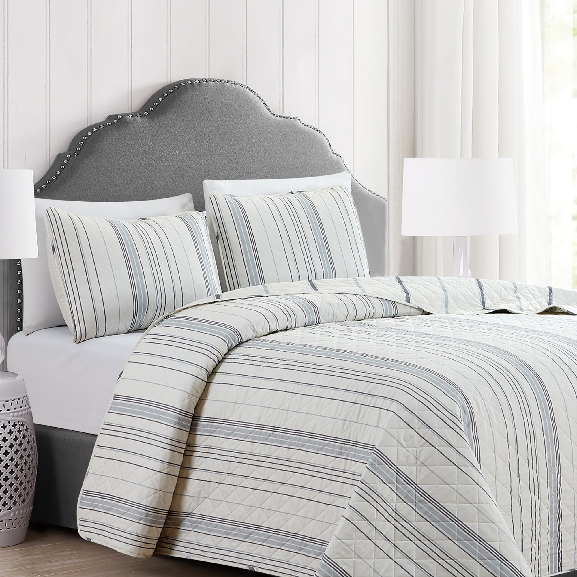 Sofia Collection striped quilt set featuring classic blue and white stripes with a reversible design, shown on beds and in close-up detail views. Soft, lightweight bedding with coordinating shams, styled in a bright and casual bedroom setting.
