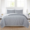 Nora Collection striped quilt set featuring classic striped patterns with a reversible dotted design, shown in multiple colorways and styling views. Soft, lightweight bedding with coordinating shams, displayed on beds and in close-up detail shots.