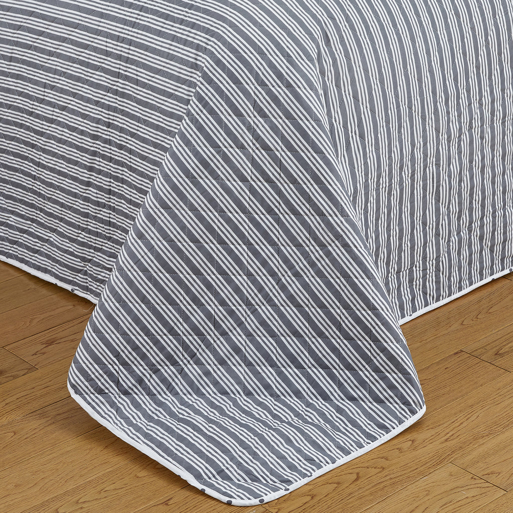 Nora Collection striped quilt set featuring classic striped patterns with a reversible dotted design, shown in multiple colorways and styling views. Soft, lightweight bedding with coordinating shams, displayed on beds and in close-up detail shots.