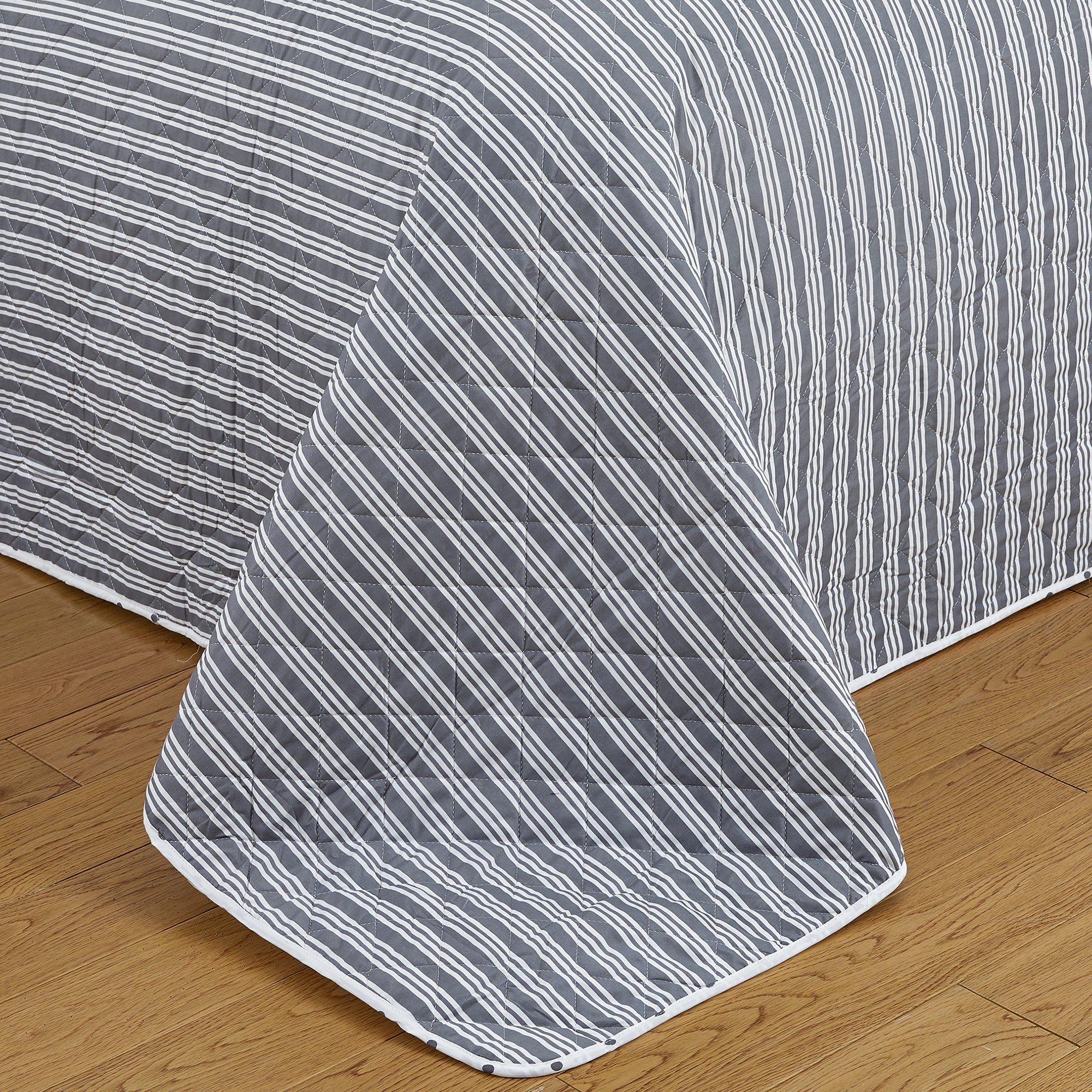 Nora Collection striped quilt set featuring classic striped patterns with a reversible dotted design, shown in multiple colorways and styling views. Soft, lightweight bedding with coordinating shams, displayed on beds and in close-up detail shots.