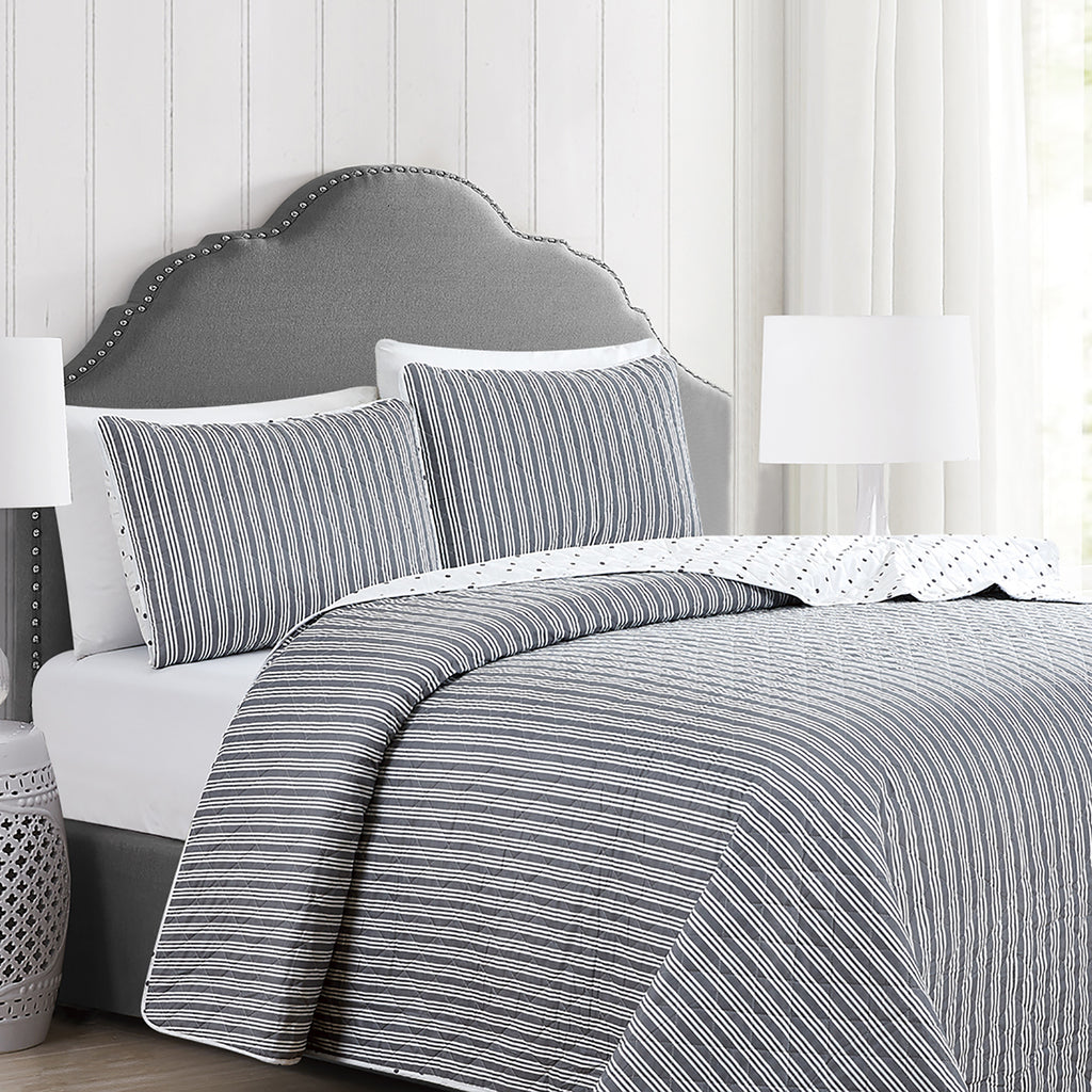 Nora Collection striped quilt set featuring classic striped patterns with a reversible dotted design, shown in multiple colorways and styling views. Soft, lightweight bedding with coordinating shams, displayed on beds and in close-up detail shots.
