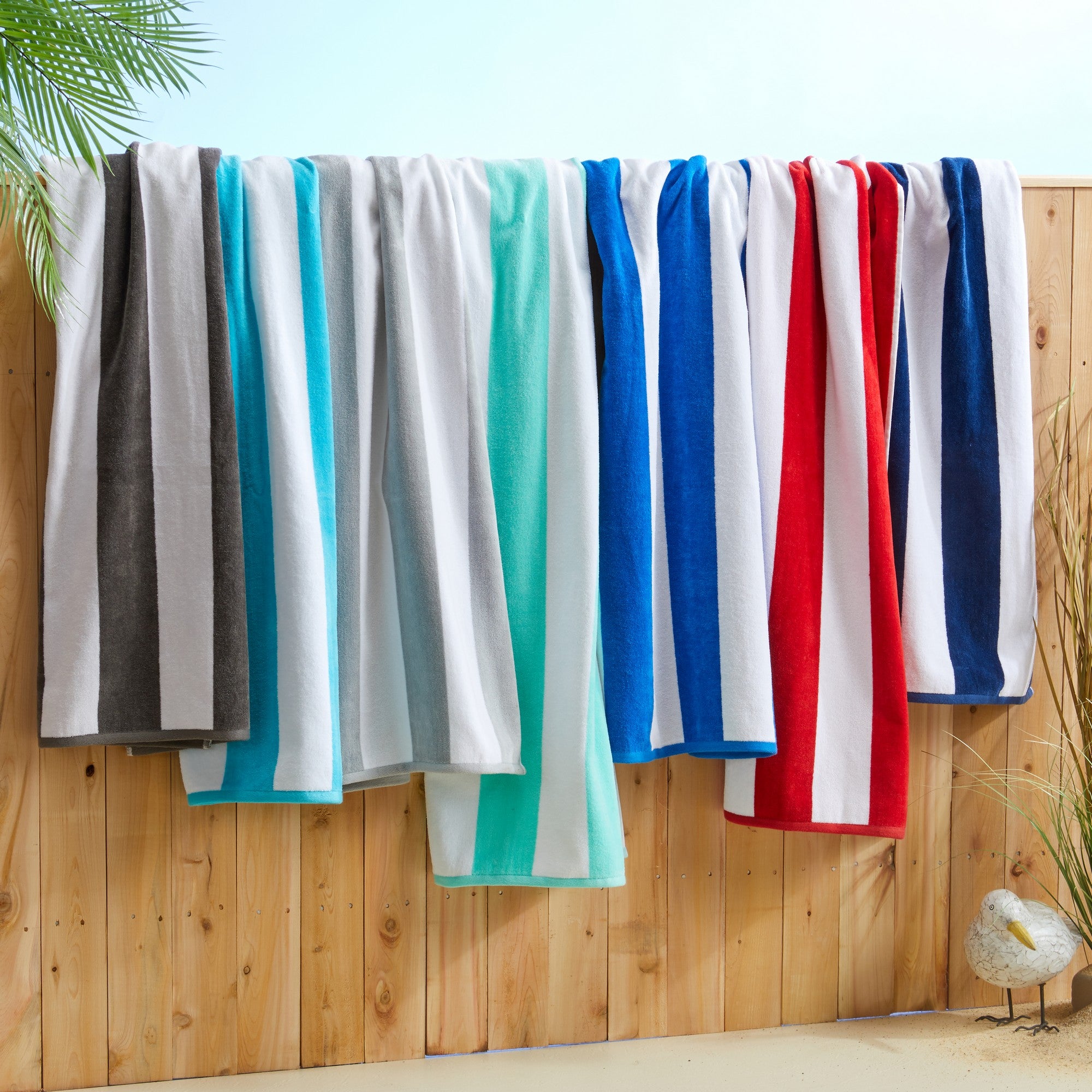 Marina Collection cotton cabana stripe beach towels in assorted colors and sizes, featuring classic striped designs and soft, absorbent 100% cotton velour construction, shown folded, stacked, and styled for poolside and beach use.