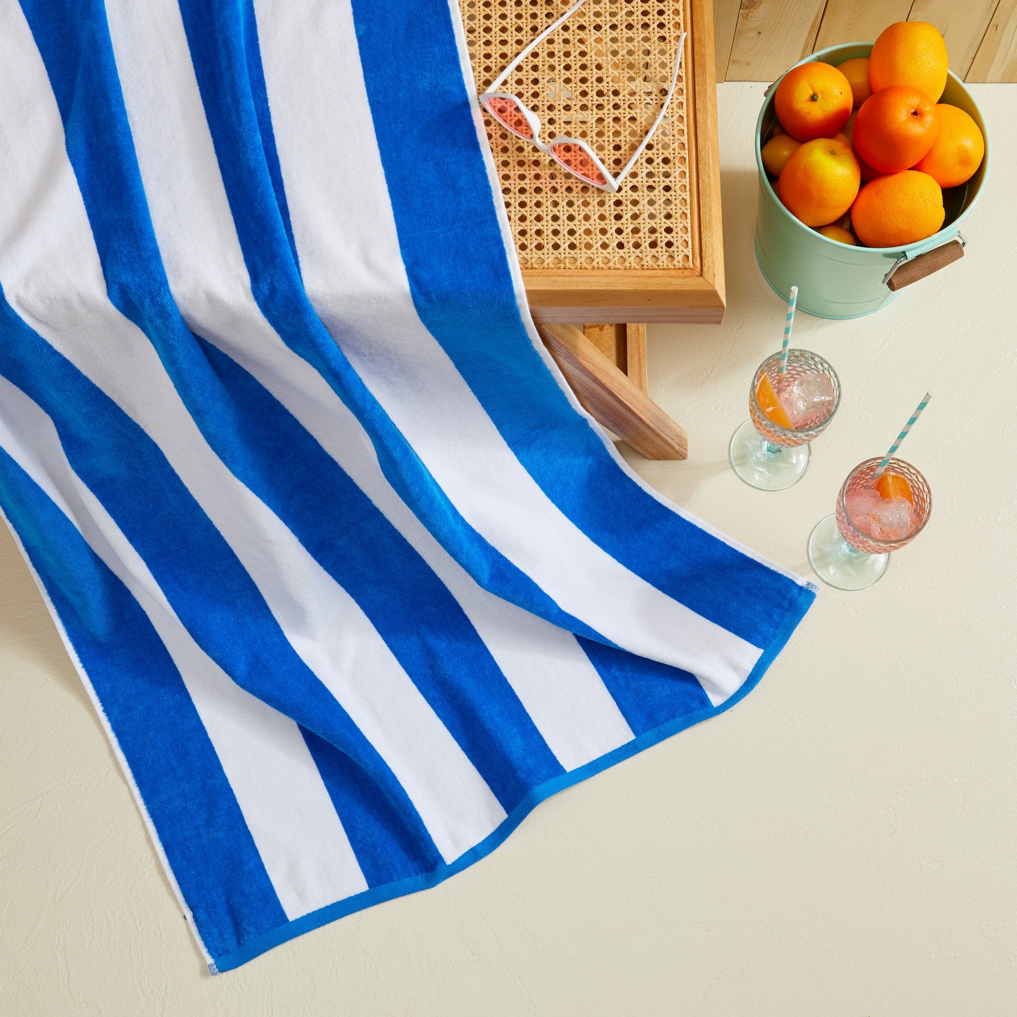 Marina Collection cotton cabana stripe beach towels in assorted colors and sizes, featuring classic striped designs and soft, absorbent 100% cotton velour construction, shown folded, stacked, and styled for poolside and beach use.