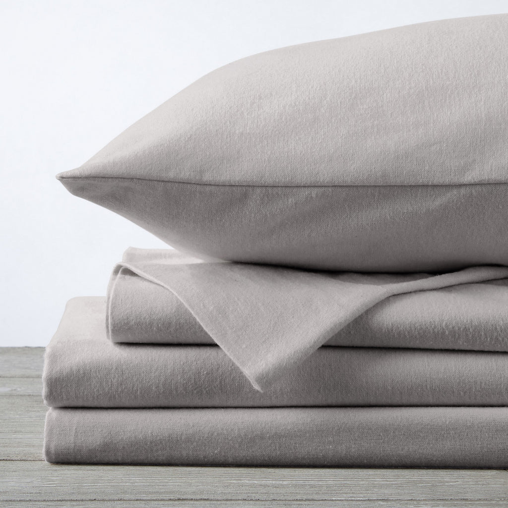 Chalet Collection Solid Flannel Sheet Set in assorted solid colors, featuring ultra-soft 100% Turkish cotton flannel bedding with coordinating pillowcases and fitted sheets, shown styled on beds and folded for detail views.