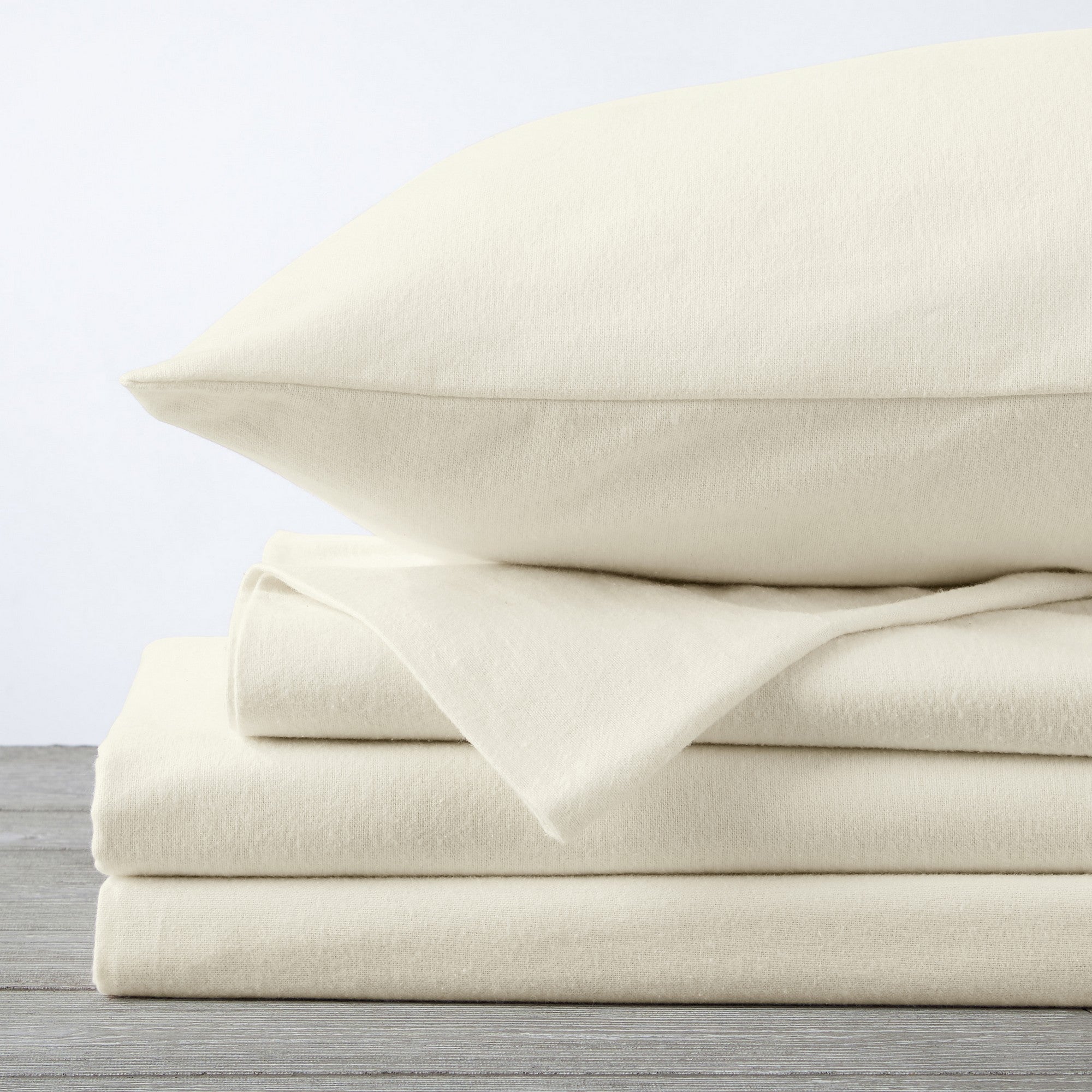 Chalet Collection Solid Flannel Sheet Set in assorted solid colors, featuring ultra-soft 100% Turkish cotton flannel bedding with coordinating pillowcases and fitted sheets, shown styled on beds and folded for detail views.