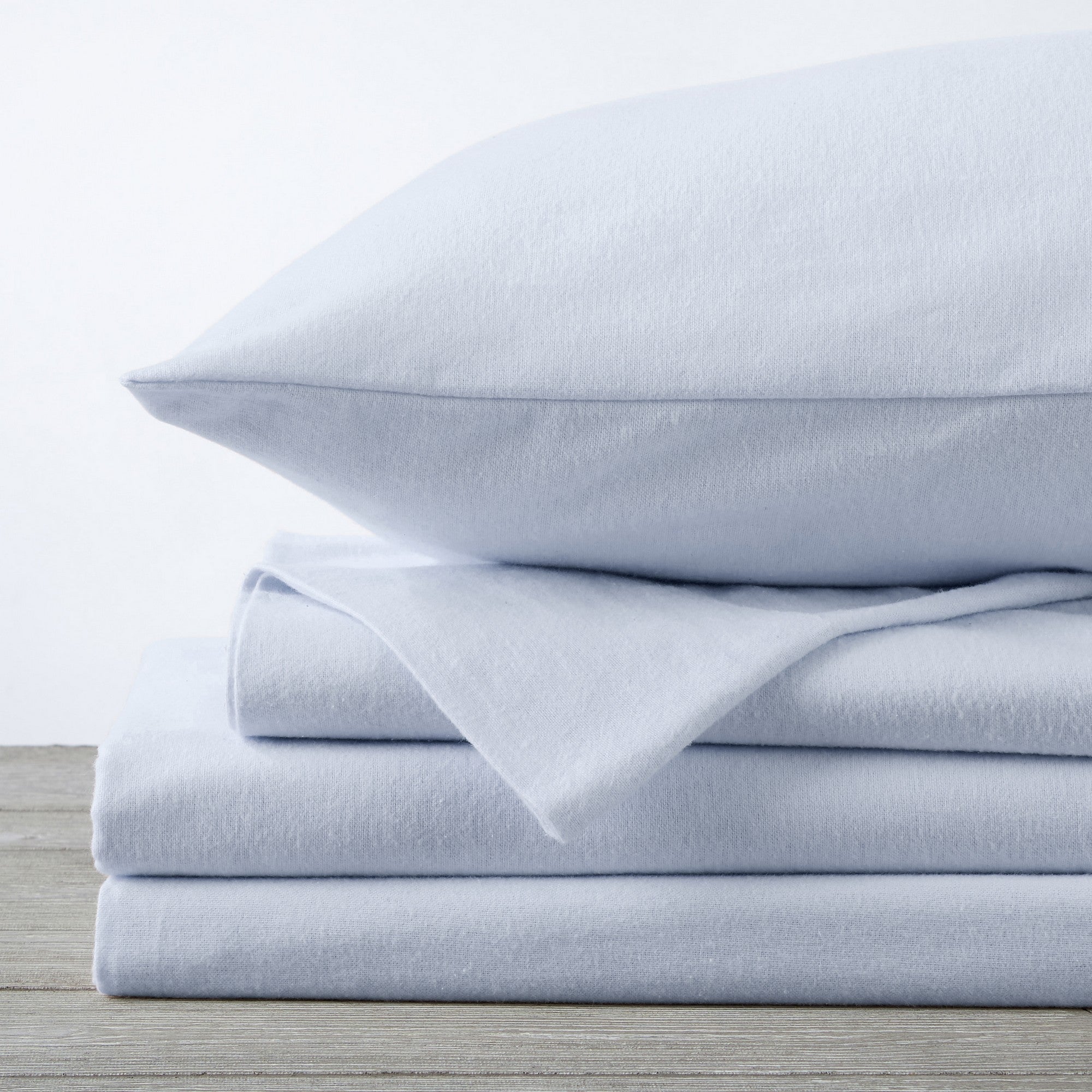 Chalet Collection Solid Flannel Sheet Set in assorted solid colors, featuring ultra-soft 100% Turkish cotton flannel bedding with coordinating pillowcases and fitted sheets, shown styled on beds and folded for detail views.