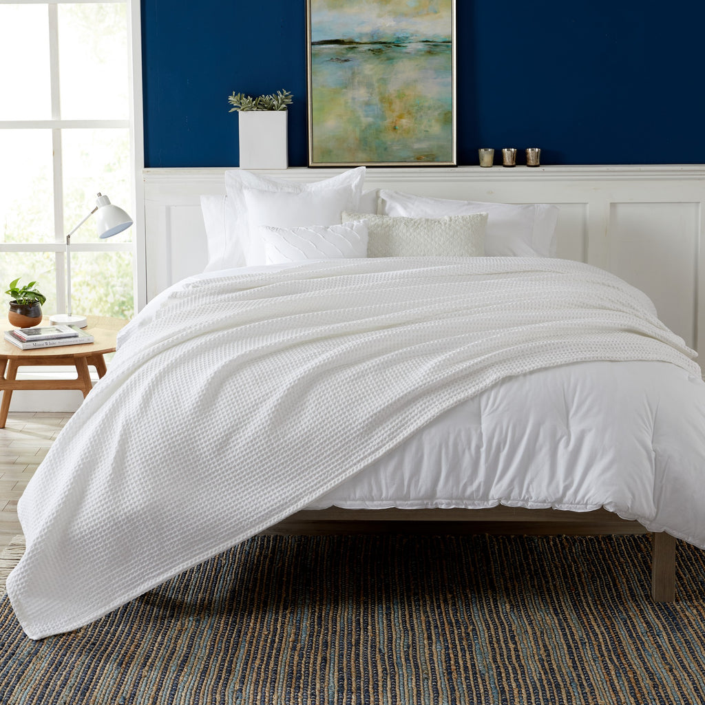 Brielle Collection Cotton Waffle Blanket by Market & Place featuring soft, breathable 100% cotton construction with a classic waffle weave texture. Available in multiple colors and shown folded, layered on beds, and in detailed fabric close-ups, highlighting its lightweight comfort and versatile year-round style.