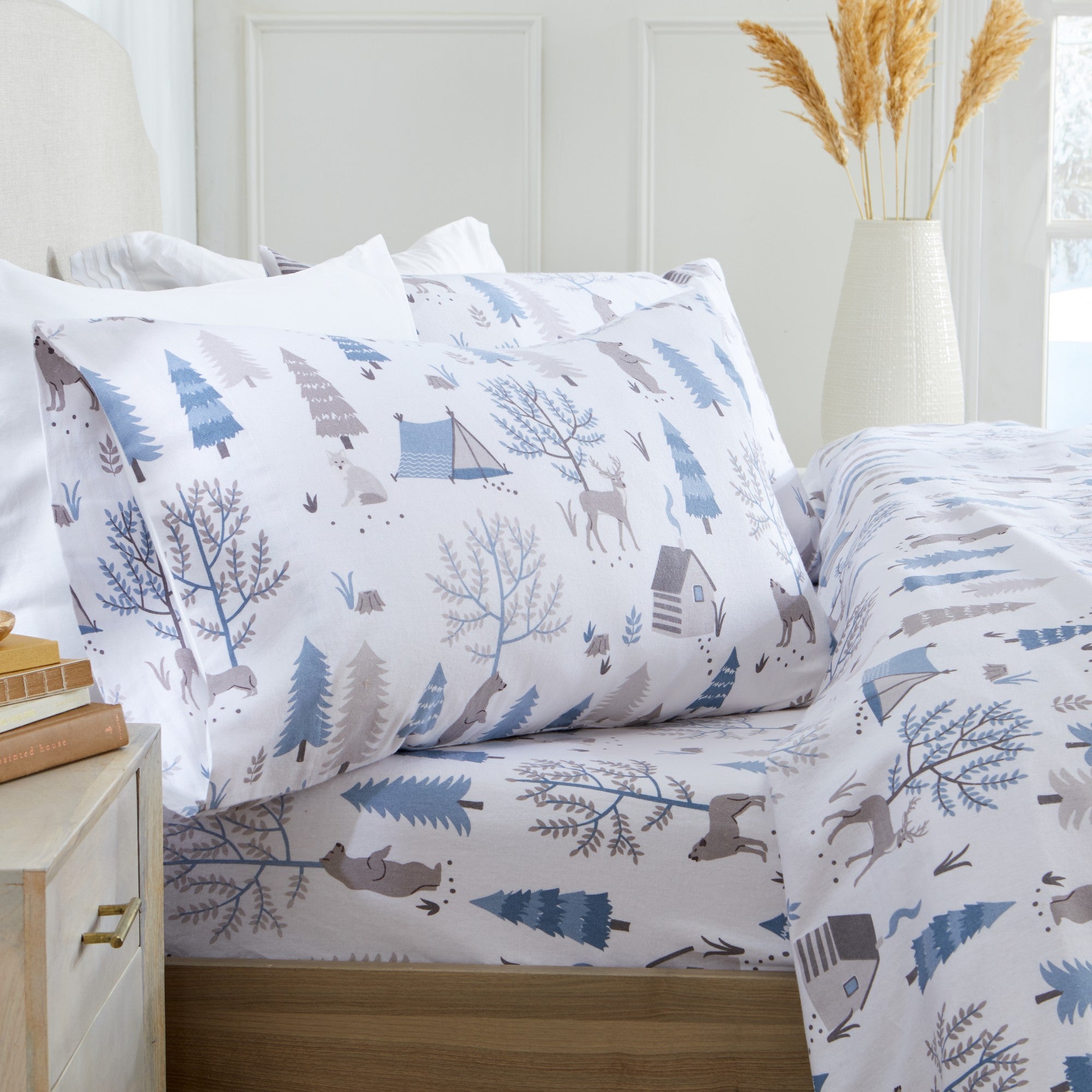 Printed 100% Turkish cotton flannel sheet set featuring assorted winter-inspired patterns, including woodland animals, snowflakes, trees, plaids, and seasonal motifs. Soft, cozy bedding shown in styled bedroom settings with close-up fabric details and folded sheet stacks in multiple designs.