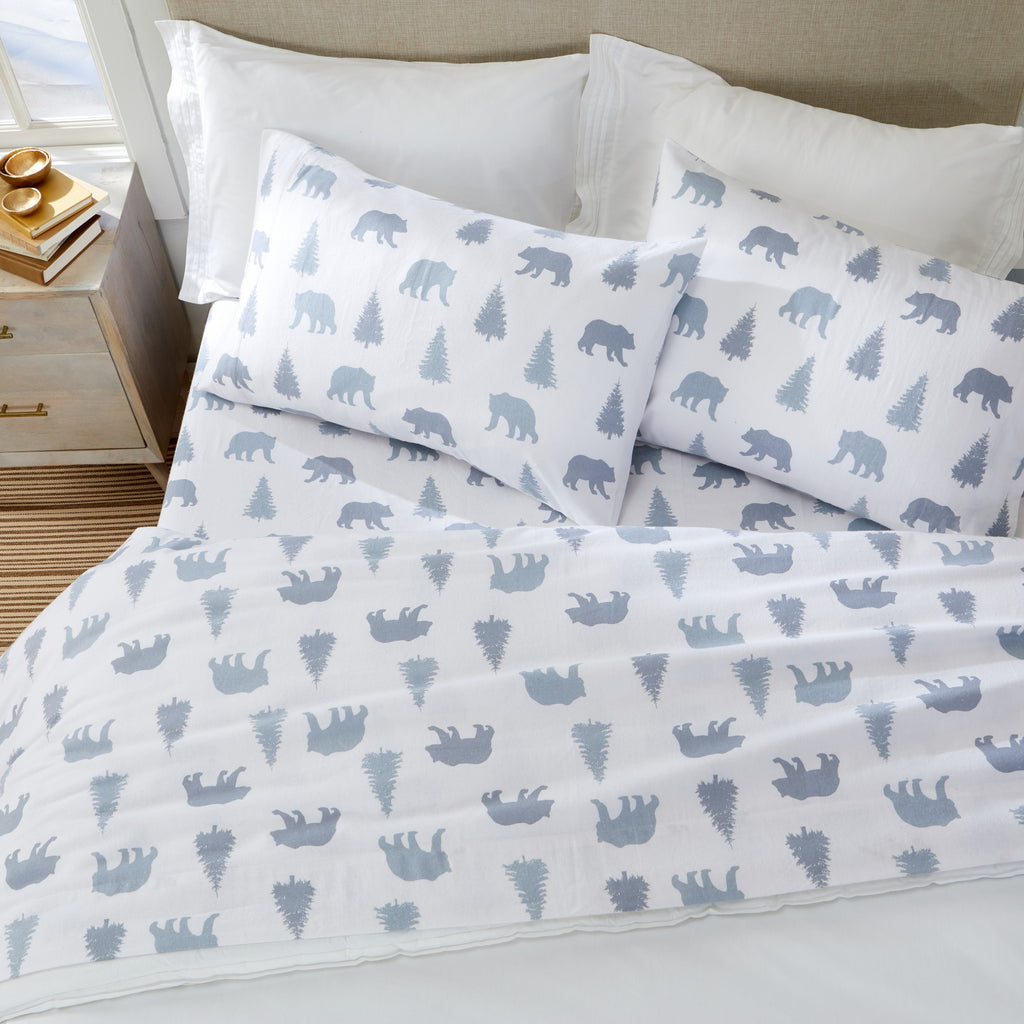 Printed 100% Turkish cotton flannel sheet set featuring assorted winter-inspired patterns, including woodland animals, snowflakes, trees, plaids, and seasonal motifs. Soft, cozy bedding shown in styled bedroom settings with close-up fabric details and folded sheet stacks in multiple designs.