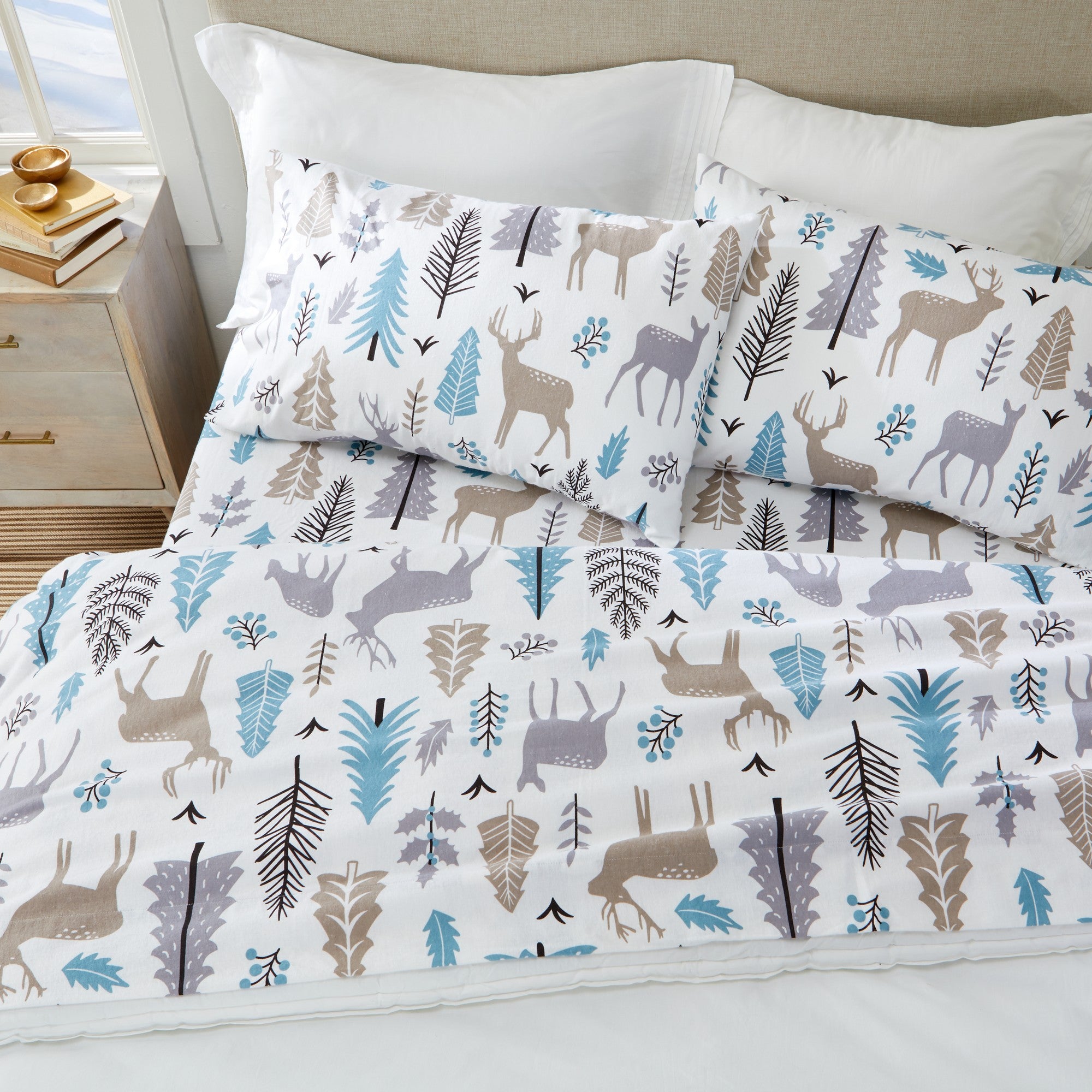 Printed 100% Turkish cotton flannel sheet set featuring assorted winter-inspired patterns, including woodland animals, snowflakes, trees, plaids, and seasonal motifs. Soft, cozy bedding shown in styled bedroom settings with close-up fabric details and folded sheet stacks in multiple designs.