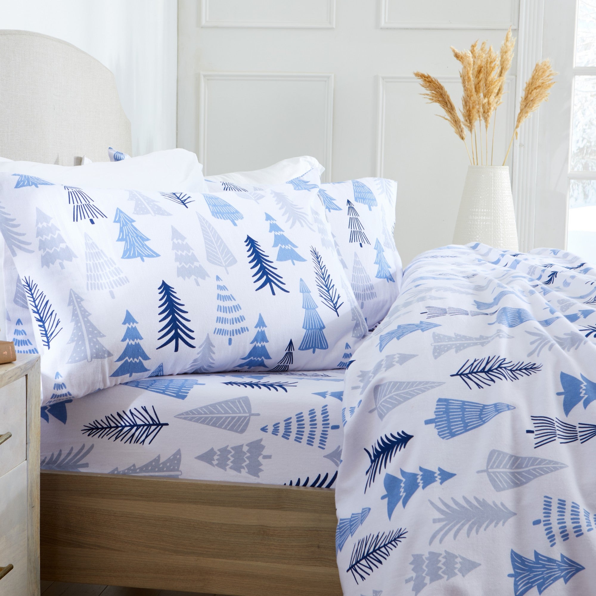 Printed 100% Turkish cotton flannel sheet set featuring assorted winter-inspired patterns, including woodland animals, snowflakes, trees, plaids, and seasonal motifs. Soft, cozy bedding shown in styled bedroom settings with close-up fabric details and folded sheet stacks in multiple designs.