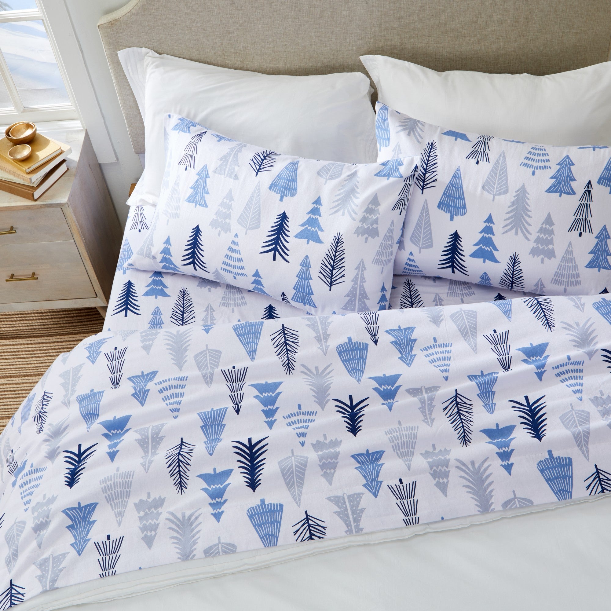 Printed 100% Turkish cotton flannel sheet set featuring assorted winter-inspired patterns, including woodland animals, snowflakes, trees, plaids, and seasonal motifs. Soft, cozy bedding shown in styled bedroom settings with close-up fabric details and folded sheet stacks in multiple designs.