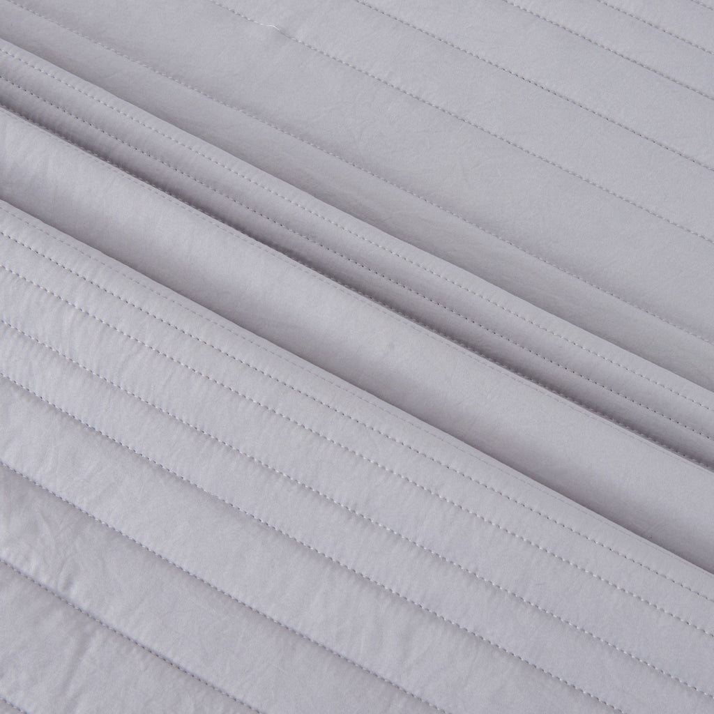 Parker Collection Solid Embroidered Quilt Set by Market & Place featuring soft microfiber construction and elegant channel embroidery. Available in multiple colors with coordinating shams and detailed fabric close-ups, styled in a modern bedroom setting.