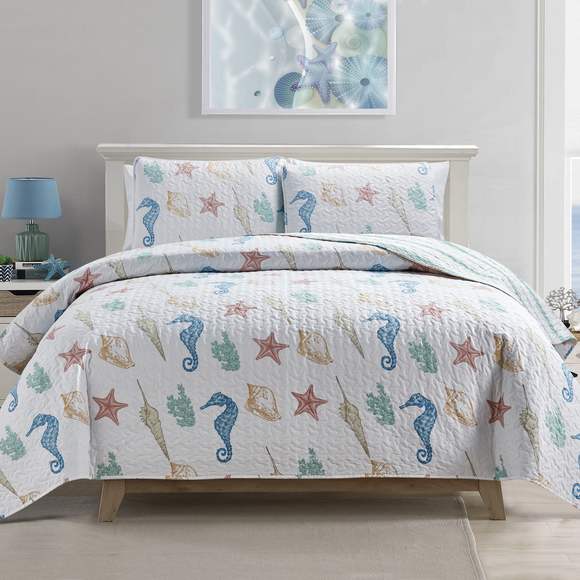 Coastal Collection Reversible Quilt Set by Market & Place featuring soft microfiber construction and coastal-inspired prints, including seashells, starfish, seahorses, coral, and ocean motifs. Coordinating shams and detailed fabric close-ups are shown in a bright bedroom setting, highlighting the reversible design and all-season comfort.