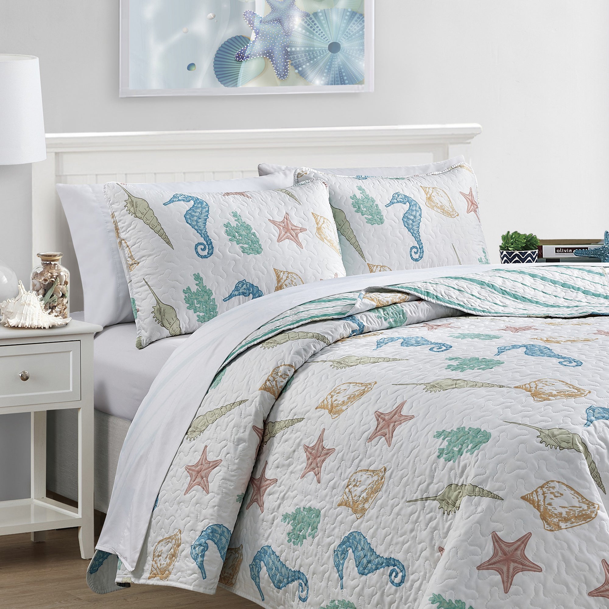Coastal Collection Reversible Quilt Set by Market & Place featuring soft microfiber construction and coastal-inspired prints, including seashells, starfish, seahorses, coral, and ocean motifs. Coordinating shams and detailed fabric close-ups are shown in a bright bedroom setting, highlighting the reversible design and all-season comfort.