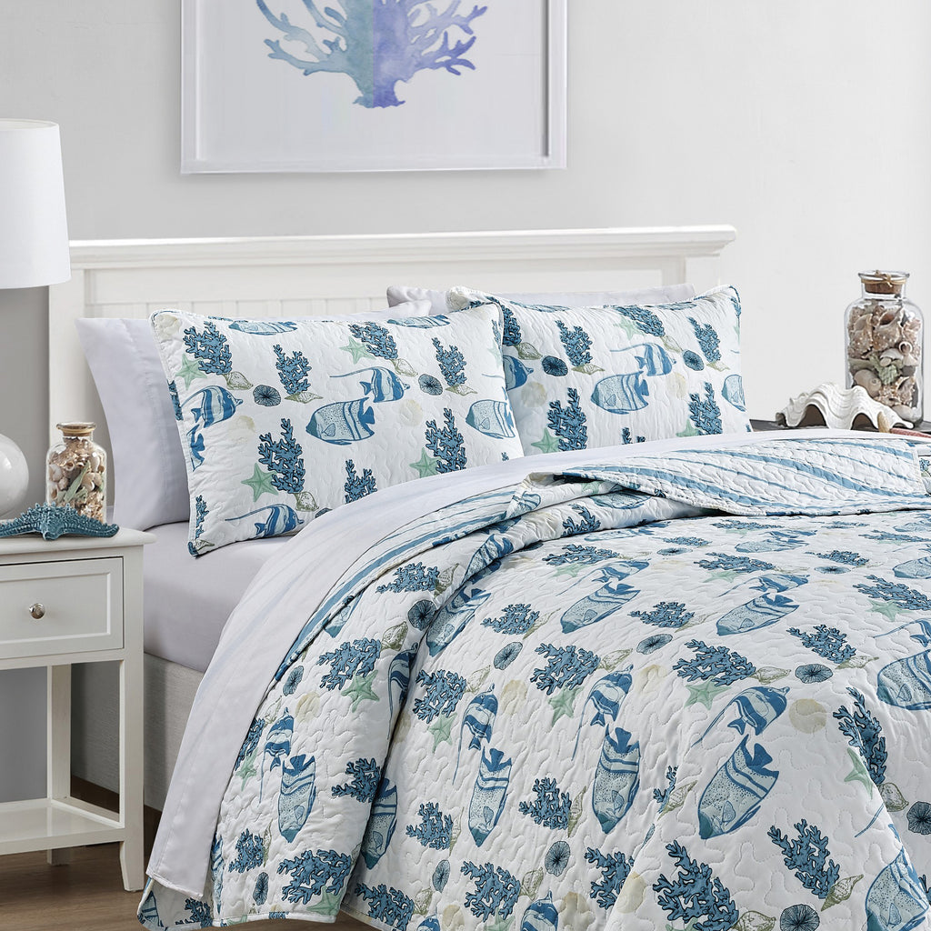 Coastal Collection Reversible Quilt Set by Market & Place featuring soft microfiber construction and coastal-inspired prints, including seashells, starfish, seahorses, coral, and ocean motifs. Coordinating shams and detailed fabric close-ups are shown in a bright bedroom setting, highlighting the reversible design and all-season comfort.