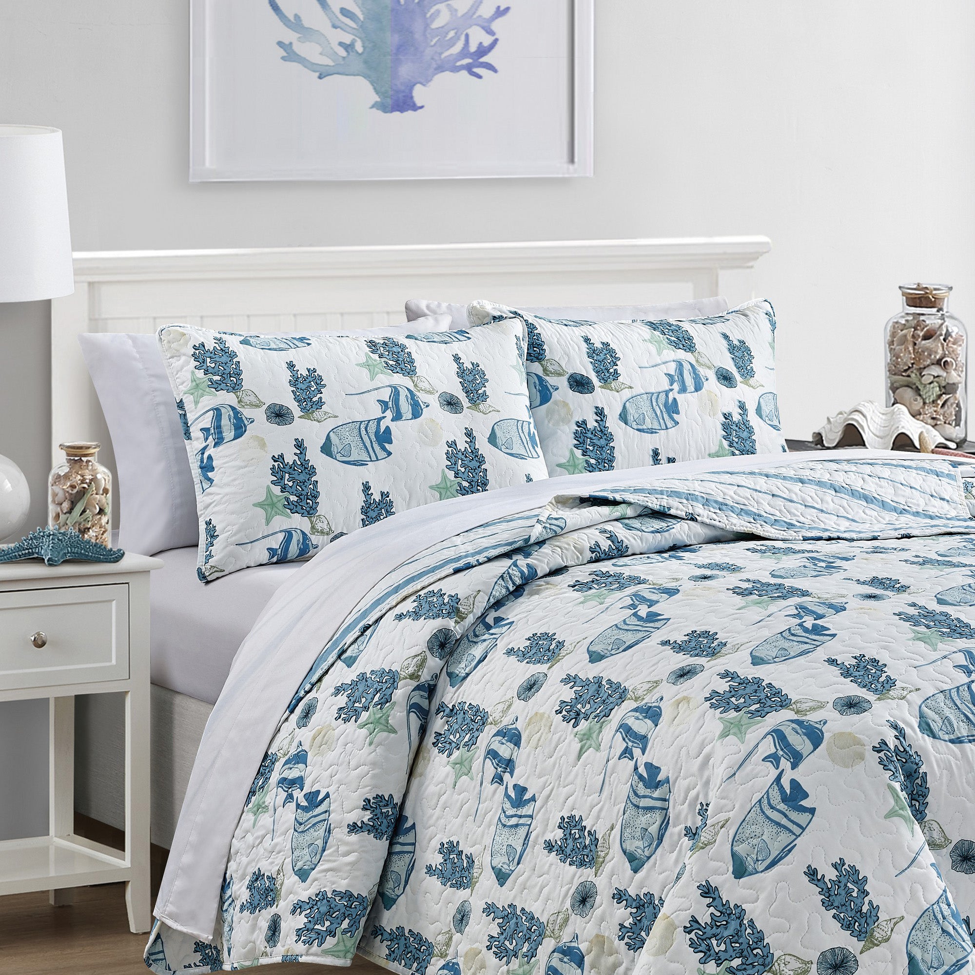Coastal Collection Reversible Quilt Set by Market & Place featuring soft microfiber construction and coastal-inspired prints, including seashells, starfish, seahorses, coral, and ocean motifs. Coordinating shams and detailed fabric close-ups are shown in a bright bedroom setting, highlighting the reversible design and all-season comfort.