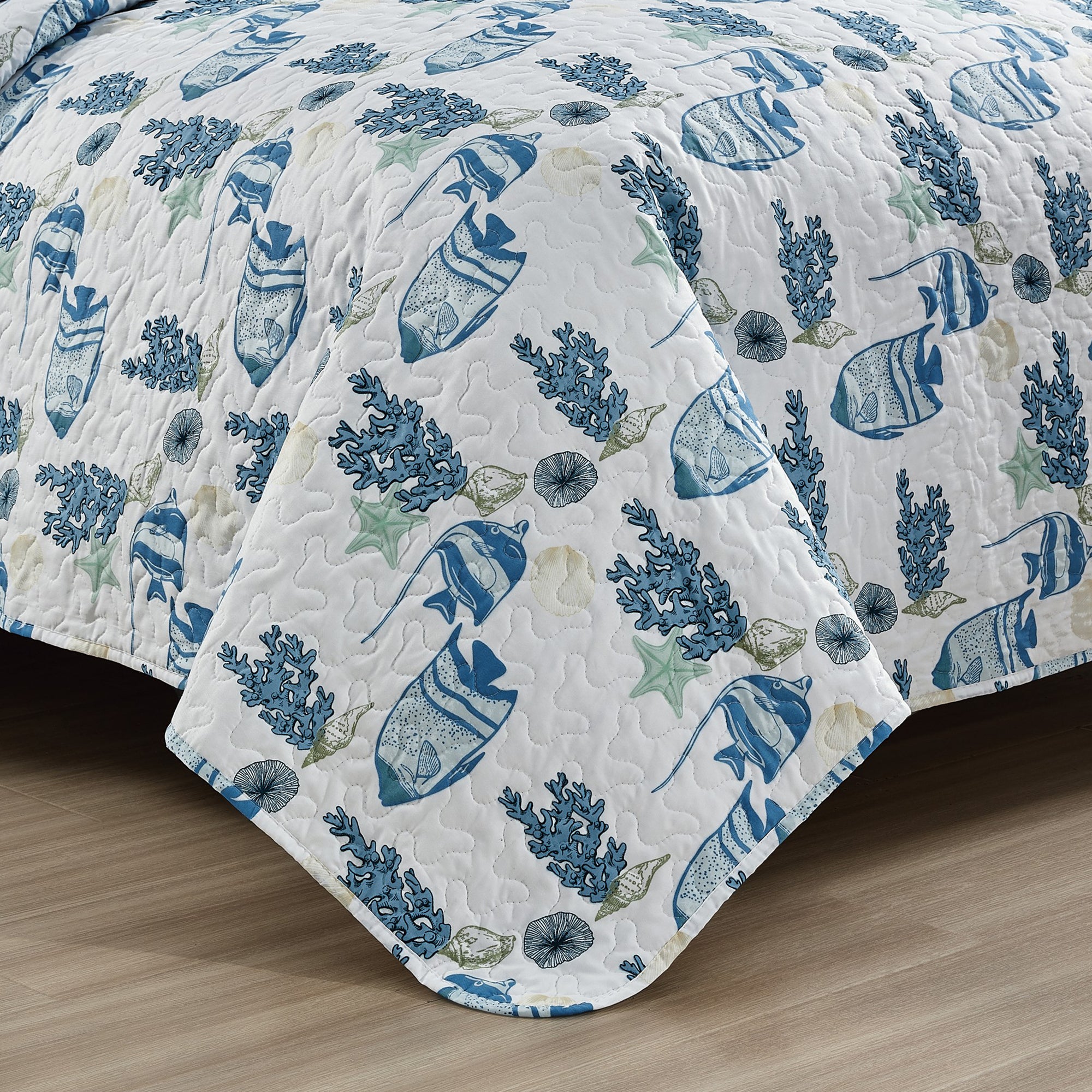 Coastal Collection Reversible Quilt Set by Market & Place featuring soft microfiber construction and coastal-inspired prints, including seashells, starfish, seahorses, coral, and ocean motifs. Coordinating shams and detailed fabric close-ups are shown in a bright bedroom setting, highlighting the reversible design and all-season comfort.