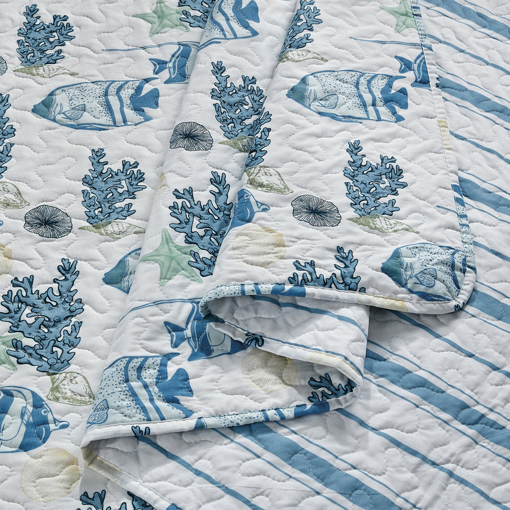 Coastal Collection Reversible Quilt Set by Market & Place featuring soft microfiber construction and coastal-inspired prints, including seashells, starfish, seahorses, coral, and ocean motifs. Coordinating shams and detailed fabric close-ups are shown in a bright bedroom setting, highlighting the reversible design and all-season comfort.