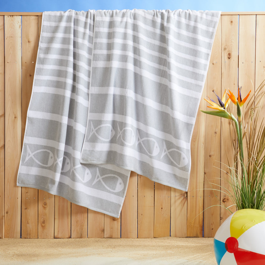 100% cotton velour beach towel featuring a colorful jacquard design, displayed on a wooden deck. Soft, absorbent, and durable, perfect for beach days, poolside lounging, and summer travel.